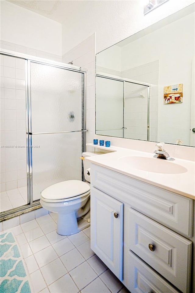 bathroom with tile patterned floors, vanity, toilet, and walk in shower