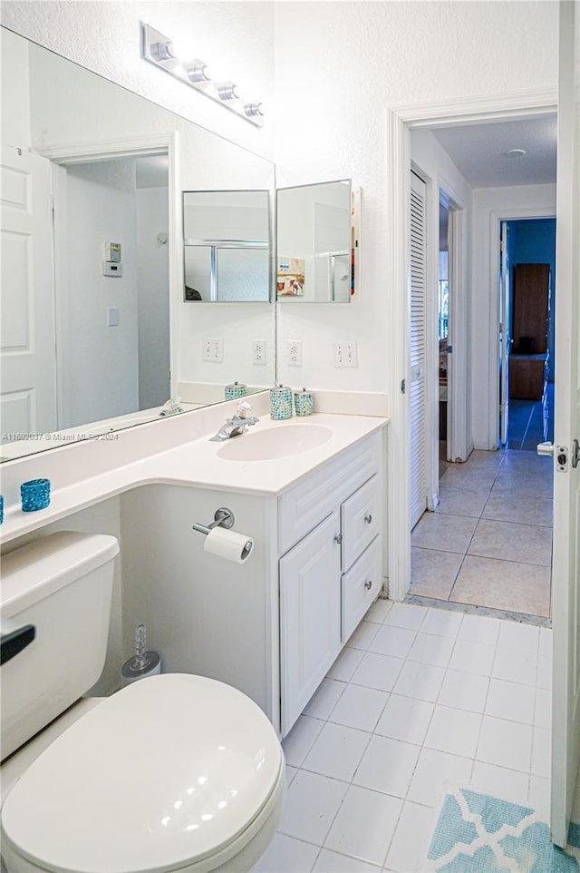 bathroom featuring toilet, vanity, and tile patterned floors