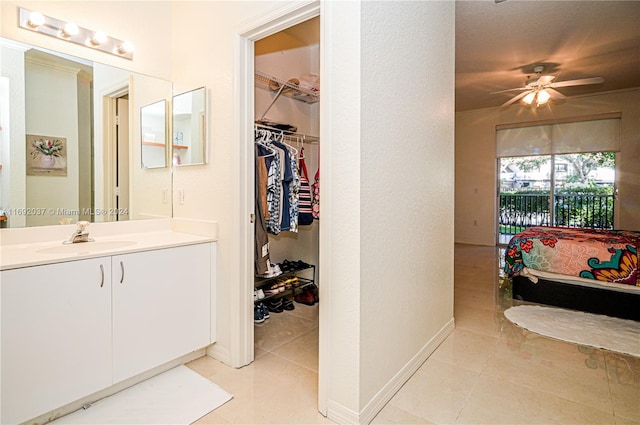 bathroom with tile patterned flooring, vanity, and ceiling fan