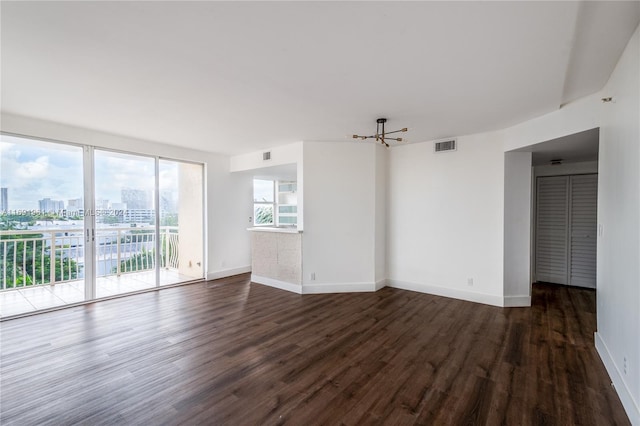 unfurnished room with dark hardwood / wood-style flooring and an inviting chandelier