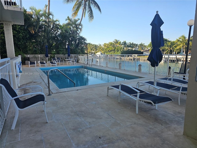 view of pool featuring a patio area and a water view