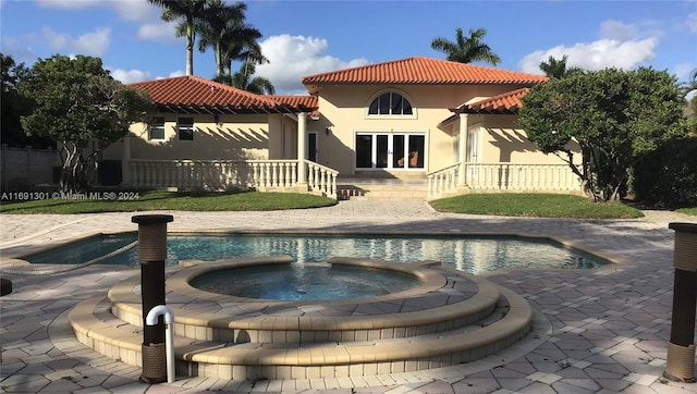 view of swimming pool featuring an in ground hot tub and a patio