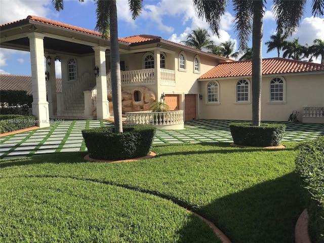 rear view of property featuring a lawn and a balcony