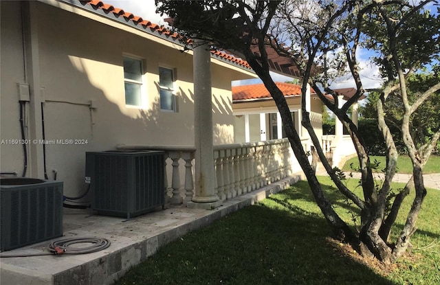 view of property exterior featuring central air condition unit and a yard