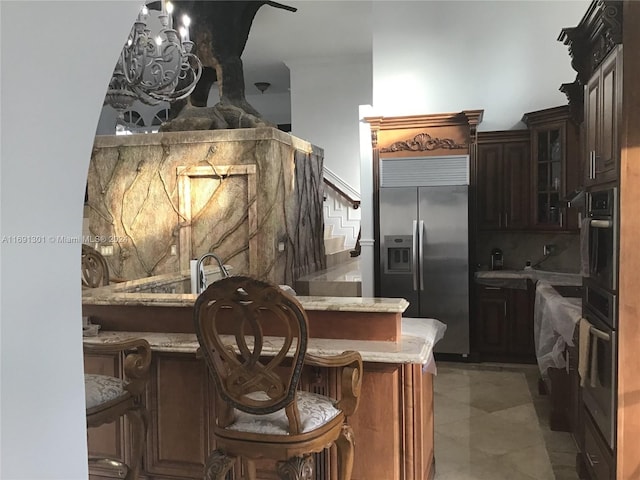 kitchen featuring light tile patterned floors, dark brown cabinets, a kitchen bar, kitchen peninsula, and stainless steel appliances