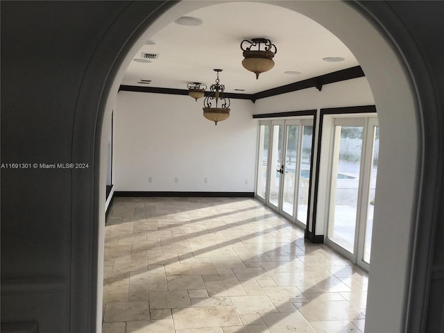 spare room featuring ornamental molding and french doors