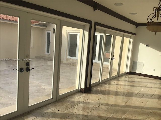 doorway to outside with ornamental molding and french doors