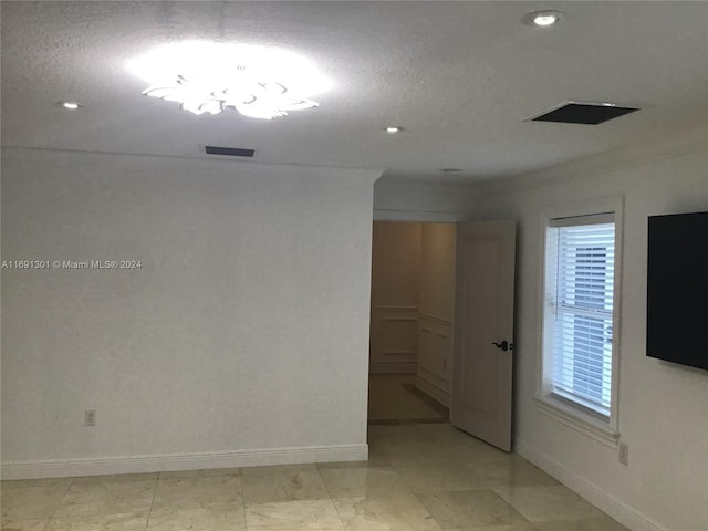 unfurnished room featuring plenty of natural light, crown molding, and a textured ceiling