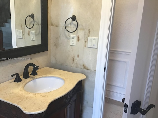 bathroom with vanity and tile walls