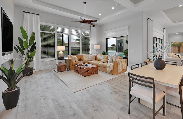 living room with ceiling fan and light hardwood / wood-style flooring