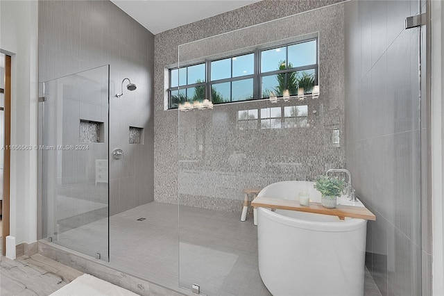 bathroom featuring separate shower and tub and tile walls