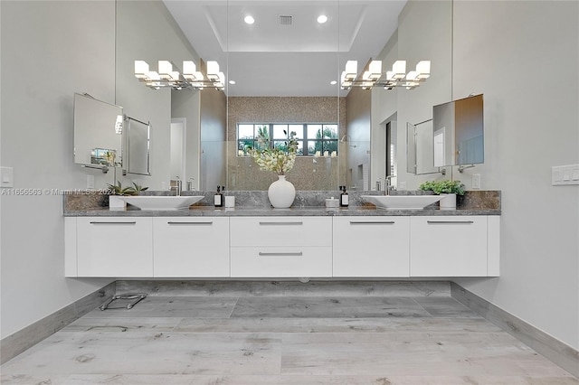 bathroom featuring a tray ceiling, vanity, and wood-type flooring