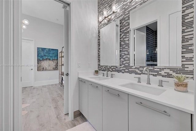 bathroom with hardwood / wood-style flooring, vanity, and decorative backsplash