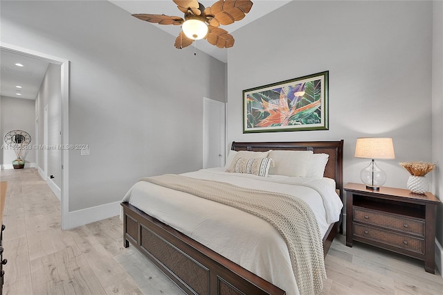 bedroom with ceiling fan, lofted ceiling, and light hardwood / wood-style floors