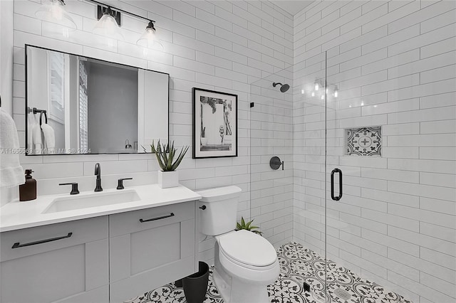 bathroom with vanity, tile walls, decorative backsplash, and a shower with shower door