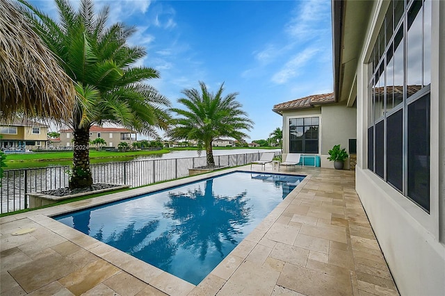 view of pool featuring a water view and a patio area