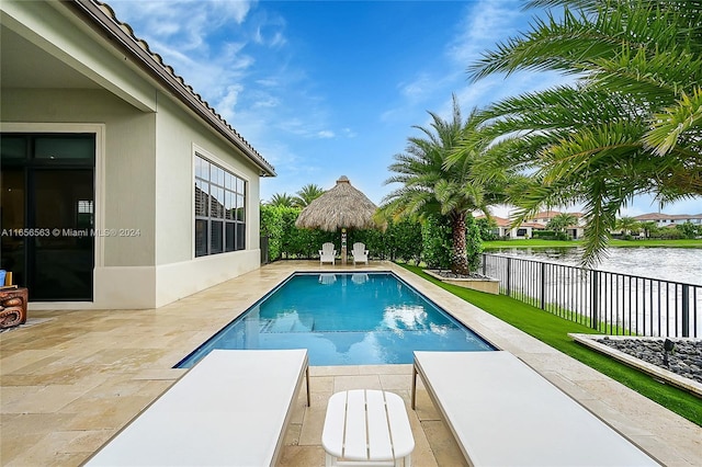 view of pool with a patio and a water view