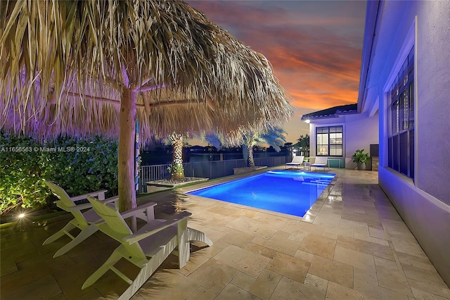 pool at dusk with a patio