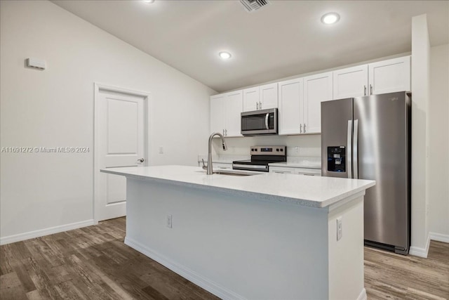 kitchen featuring a kitchen island with sink, white cabinets, stainless steel appliances, and vaulted ceiling