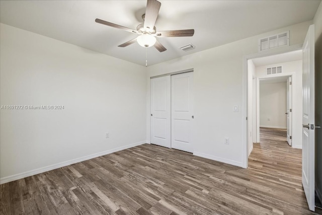 unfurnished bedroom featuring ceiling fan, wood-type flooring, and a closet