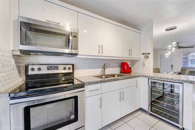 kitchen featuring white cabinetry, sink, stainless steel appliances, wine cooler, and a textured ceiling