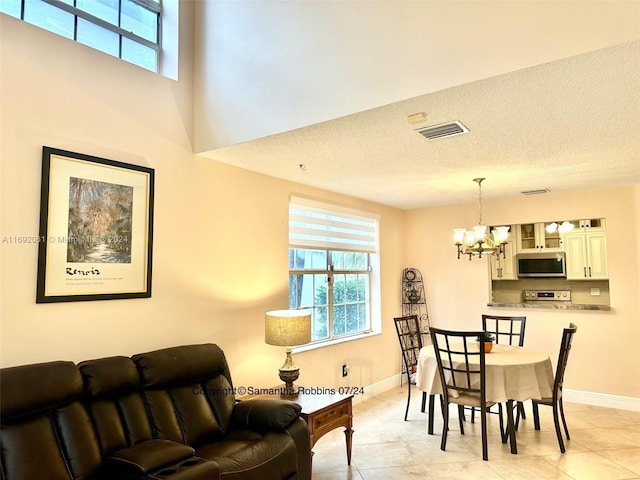 tiled dining area with a textured ceiling and an inviting chandelier