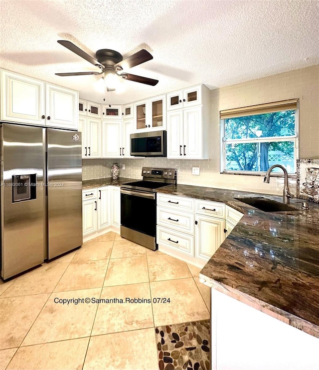 kitchen with a textured ceiling, ceiling fan, sink, and appliances with stainless steel finishes