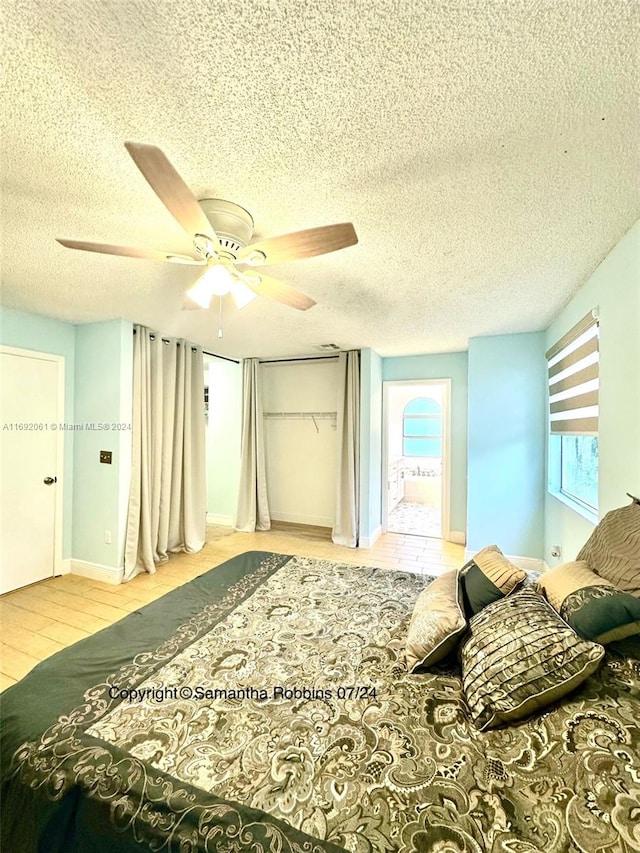 bedroom with ceiling fan, light hardwood / wood-style flooring, and a textured ceiling