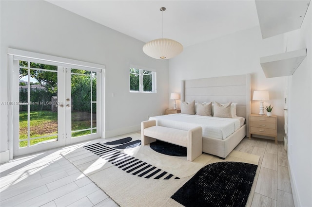 bedroom featuring access to exterior, french doors, and light wood-type flooring