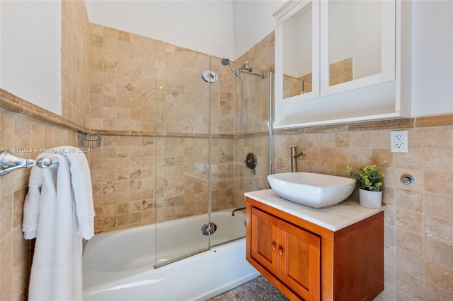 bathroom with vanity, enclosed tub / shower combo, and tile walls