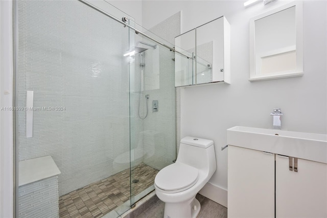 bathroom with an enclosed shower, vanity, and toilet