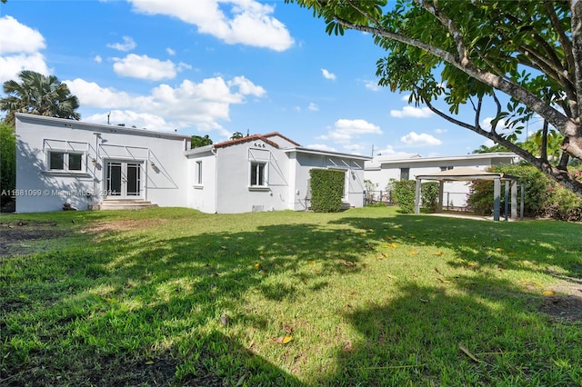 rear view of property featuring a yard and french doors