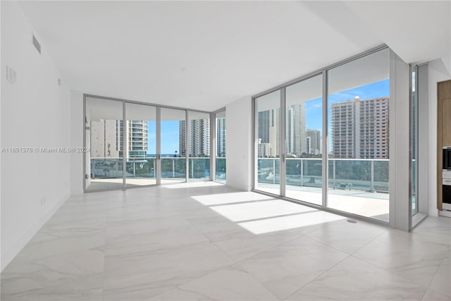 unfurnished room with expansive windows