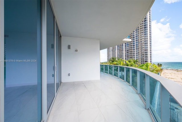 balcony featuring a beach view and a water view