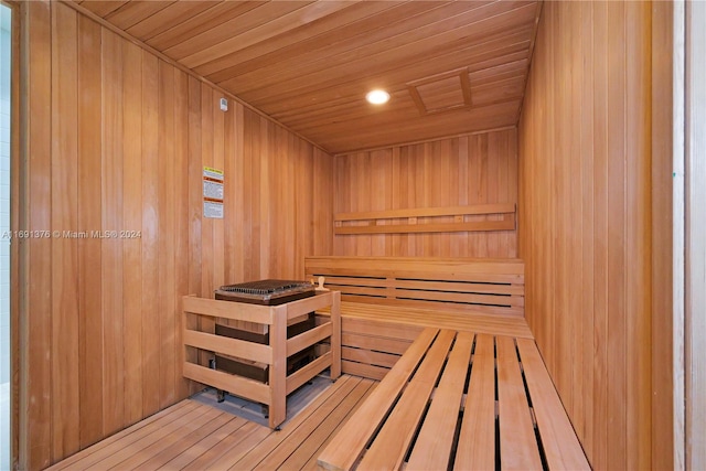 view of sauna with hardwood / wood-style flooring, wood walls, and wooden ceiling