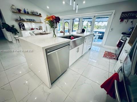 kitchen featuring stove, an island with sink, sink, white cabinetry, and stainless steel dishwasher