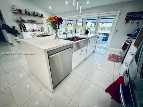 kitchen featuring stainless steel dishwasher, sink, white cabinets, stove, and a kitchen island with sink