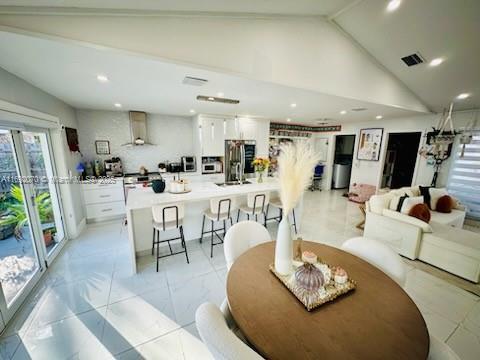 dining space featuring high vaulted ceiling