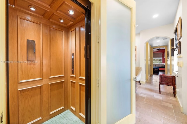 hall with elevator and coffered ceiling