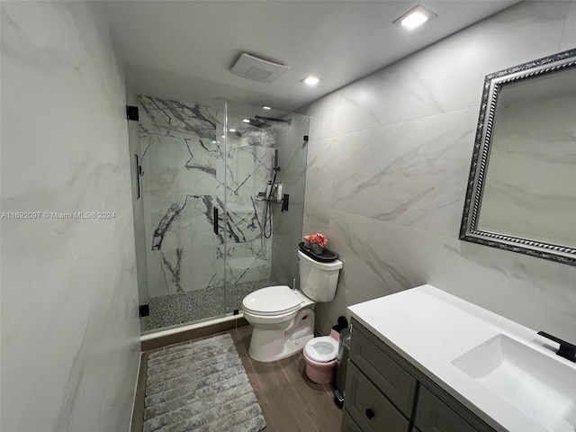 bathroom with walk in shower, hardwood / wood-style floors, vanity, and toilet