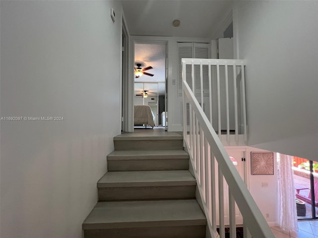 staircase with tile patterned flooring and ceiling fan