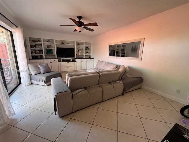 living room featuring built in shelves, ceiling fan, and light tile patterned floors