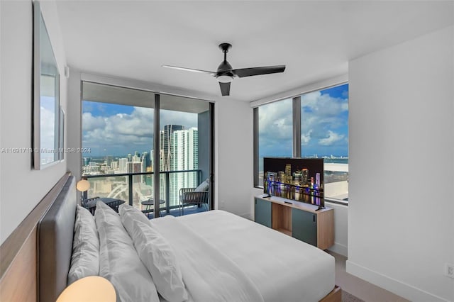 bedroom featuring multiple windows, floor to ceiling windows, and ceiling fan