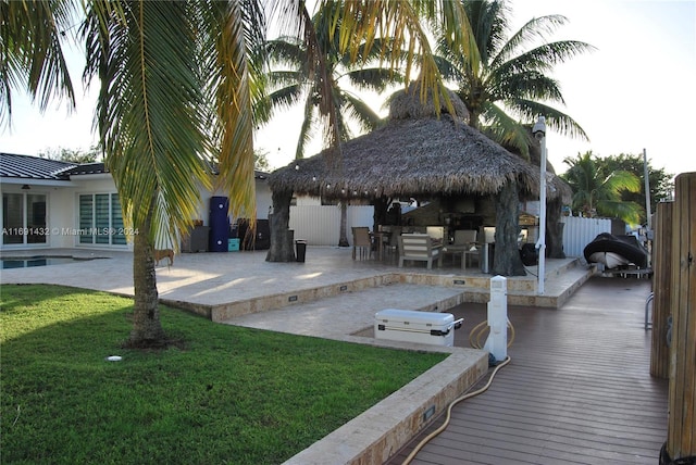 exterior space featuring a gazebo, a lawn, a bar, and a patio