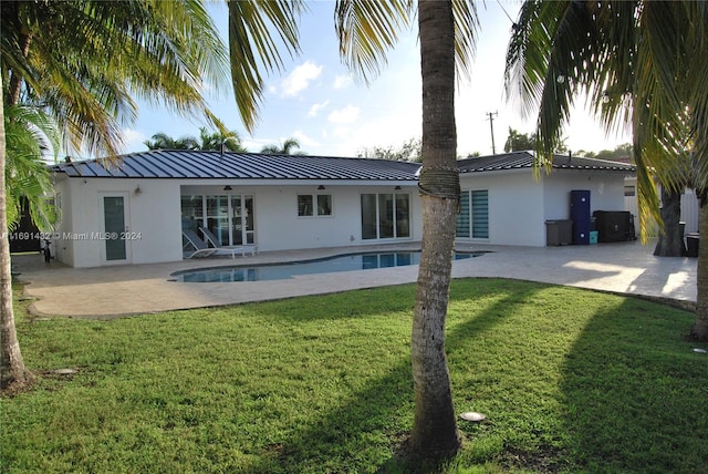 rear view of property with a yard and a patio