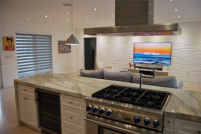 kitchen with pendant lighting, high end range, wine cooler, island range hood, and light stone counters