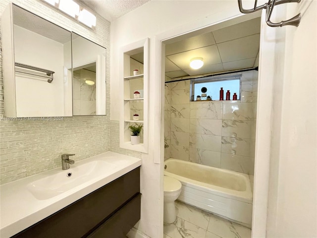 full bathroom with decorative backsplash, vanity, tiled shower / bath combo, and toilet