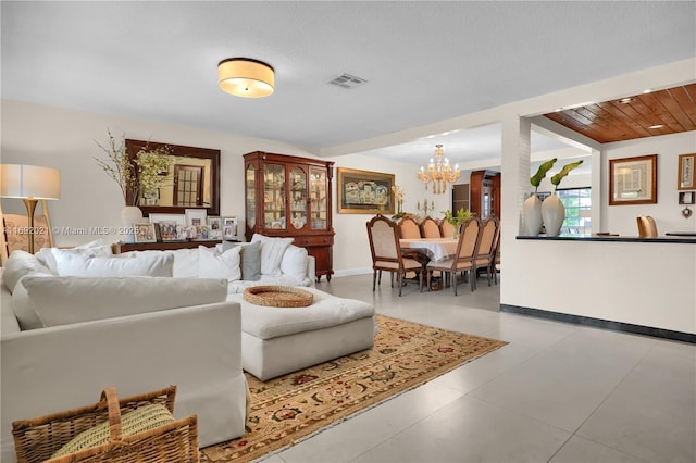 living room with an inviting chandelier, visible vents, and baseboards