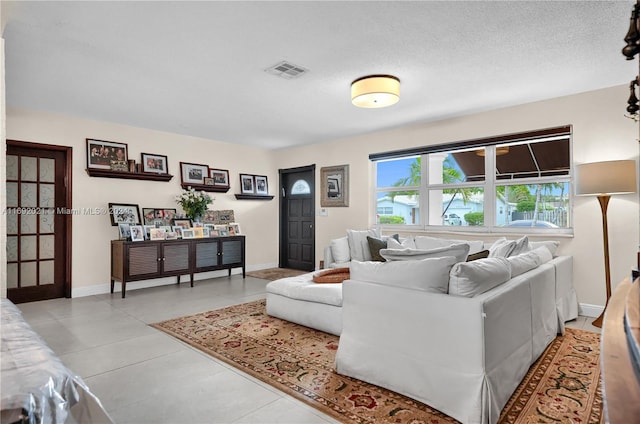 tiled living room featuring a textured ceiling