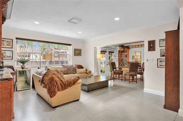 living room featuring french doors, beverage cooler, a textured ceiling, light tile patterned floors, and crown molding